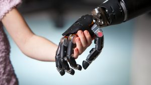 robotic hand holds little girl's hand