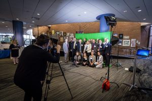 Johns Hopkins Engineering for Professionals instructors pose for a group photo in front of a green screen