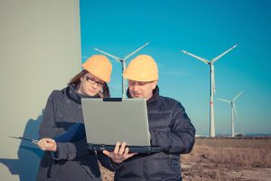 stock workers out in the field with wind turbines