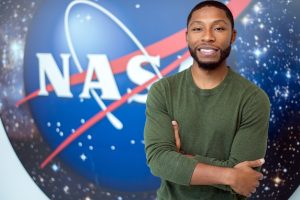 Engineering Management alumni Kenneth Harris II in front of the NASA logo