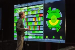 A man interacting with data visuals displayed on a screen.