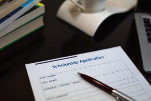 A scholarship application with a pen on a desk.
