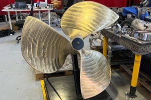A large metallic propeller, part of the Ramlab MaxQ robot, sitting in a workshop. 
