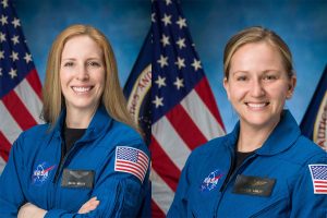 NASA portrait photos of Imelda Mueller and Rebecca Lawler in flight suits behind the U.S. and NASA flags.