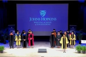 image of stage participants standing wearing regalia